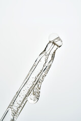 Cosmetic pipette dropping liquid serum with bubbles