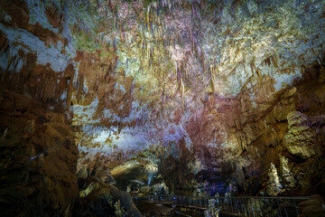 Gigantic colorful cave chamber with stalactites above elevated tourist walkway