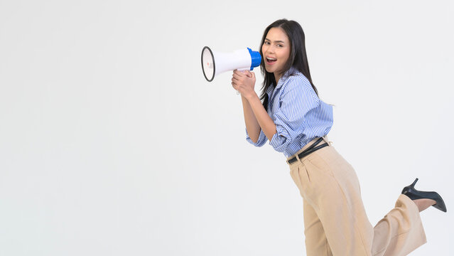 Young Woman Enthusiastically Engages With a Megaphone in a Bright Studio Setting