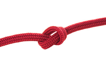 A close-up of a tight red rope knot showcases its detailed weave and texture. This knot is often used in climbing, sailing, and crafting projects for secure fastening