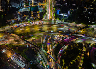 Aerial top view of busy multilane highway interchange in Jakarta, Indonesia, at night. Perfect for...