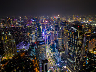 Aerial view of Jakarta city skyline at night. Modern skyscrapers, glowing lights, and busy traffic highlight vibrant energy of Indonesia's capital. Perfect for travel, city, and business themes.