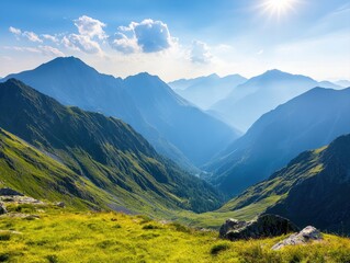 Obraz premium A breathtaking view of mountains and valleys bathed in sunlight, showcasing lush greenery and serene landscapes under a clear blue sky.