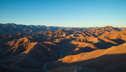 Aerial view of desert landscape with mountains under blue sky