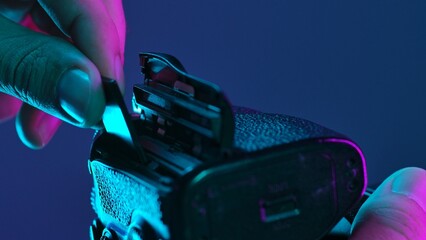Close Up of Hand Inserting Memory Card into Camera