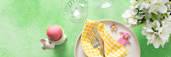A vibrant Easter table setting features yellow checkered napkins wrapped with twine, a decorative plate, and fresh flowers, creating a festive atmosphere for spring gatherings, banner