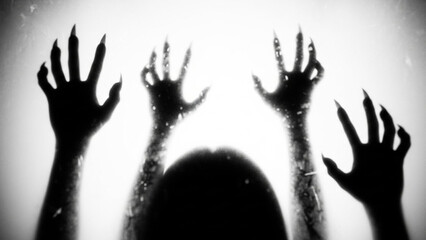 Silhouette of a scary monster or demon with long sharp claws reaching up against a bright white background, creating a terrifying and suspenseful horror atmosphere