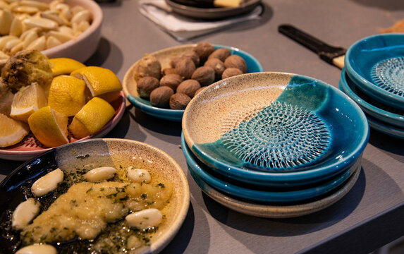 Colorful stacks of grating plates and serving dishes with prepared ingredients, cooking process