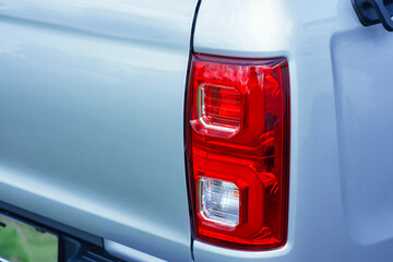 Close-up view of a pickup truck rear tail light with red and white lenses. Modern car lighting.