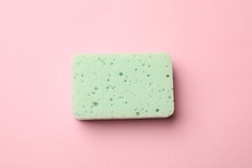 One kitchen sponge on pink background, top view