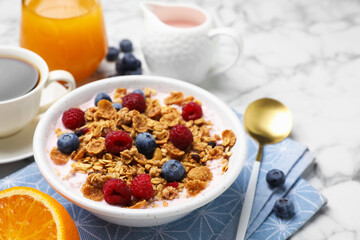 Tasty breakfast. Granola with yogurt and fruits served on white marble table, closeup