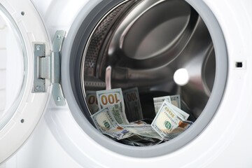 Many dollar banknotes in washing machine, closeup