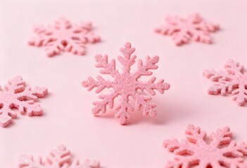 Fototapeta premium Delicate pink snowflake decorations scattered across a soft pastel background
