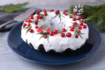 Tasty Christmas cake with cranberries and rosemary on gray wooden table, closeup