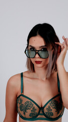 Woman in black lingerie and dark glasses blindfold poses mysteriously