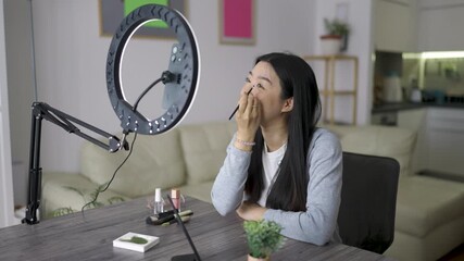 A young Thai girl films an easy beauty vlog at home, applying simple makeup and explaining each step. The video has a friendly and casual feel, perfect for lifestyle and beauty content.