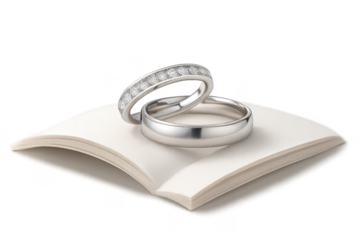 Elegant wedding rings on an open book, isolated on a transparent background.