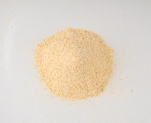 Garlic powder pile isolated, dried granulated chopped crushed garlic on white background