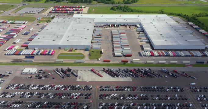 Parked new cars at the automotive plant factory parking lot ready for sale. Development of American industry concept.