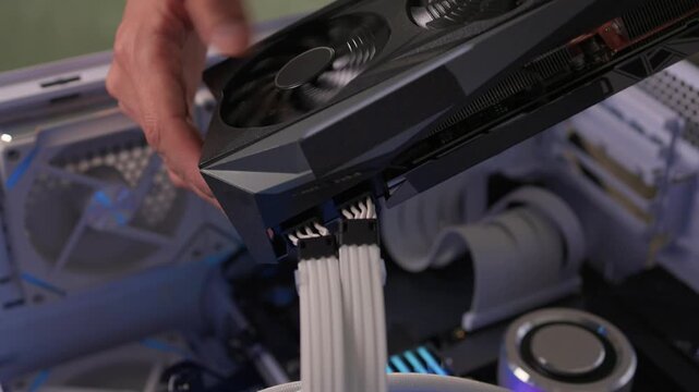 Building computer with careful assembly, Installing components with precise attention to detail, Assembling desktop computer featuring graphics card and lighting effects