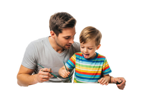 Young caucasian father (30s) and happy son (6) in striped tee painting watercolors at a wooden table in bright high-key studio setting with copy space. Concept of family creative collaboration - Powered by Adobe