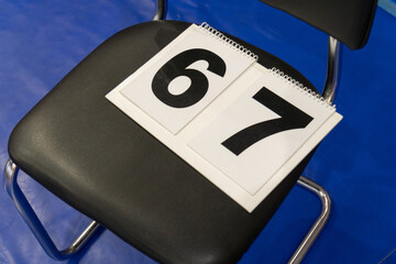 A close-up, high-angle shot of two white number signs, displaying the black digits 6 and 7