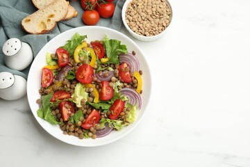 Delicious lentil salad and ingredients on white marble table, flat lay. Space for text