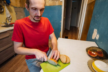 chef prepares slices, individual slices bread on kitchen surface, person slices loaves in cozy kitchen environment, person meticulously cuts slices of bread while preparing meal at home