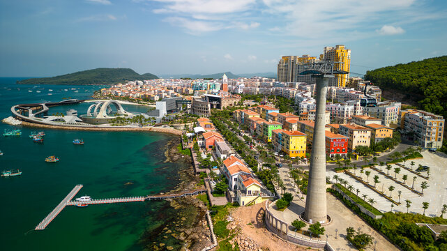 Aerial view of Sunset Town in Phu Quoc with colorful buildings, the coastal cable car, and the Kiss Bridge. Scenic tropical waterfront and vibrant seaside architecture in Vietnam.