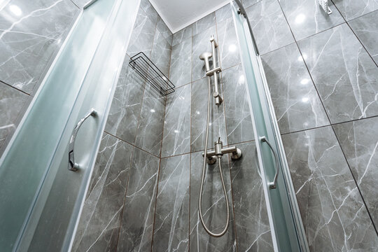 contemporary bathroom elements, chic glass shower enclosure design, elegant bathroom partition with marble and glass, stylish shower zone featuring stainless steel fixtures and marble accents