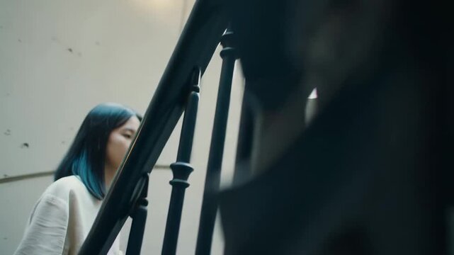 Woman ascending staircase: capturing movement, focus, and determination in urban setting