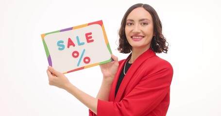 Smiling woman in red jacket holds bright board with word Sale and percent. Marketer presents seasonal promotion message inviting customer attention