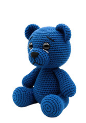 a macro close-up of a meticulously detailed amigurumi teddy bear, deep cobalt blue crochet yarn, sitting passively on a pure white studio background with copy space. concept of gentle sadness and