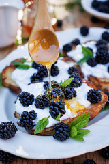 French toast with cream cheese, fresh blackberries and honey, close-up view