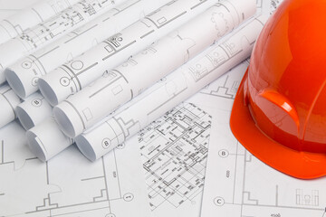 Paper architectural drawings, blueprint and helmet.