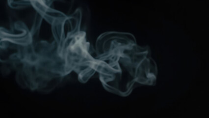 Fototapeta premium Abstract wisps of smoke against a dark background, creating a mysterious atmosphere