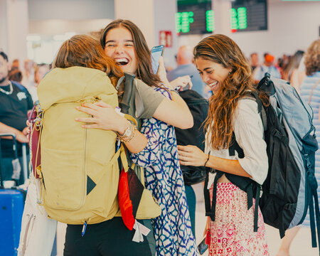 Happy friends hugging at train station reunion before travel - Powered by Adobe