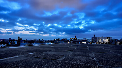 Obraz premium Cityscape Under Dramatic Blue Sky with Cloudy Evening View, Liminal