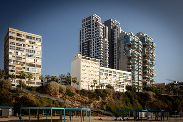 Bat Yam, Israel, November 25, 2025 Contrast between old and new high-rise residential buildings on a sandy cliff overlooking a beach.