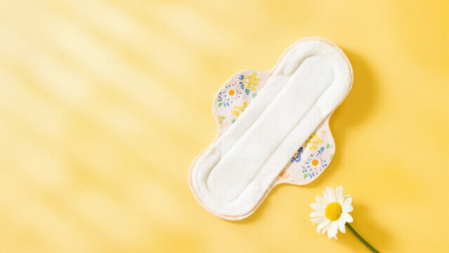 Reusable menstrual pad with floral pattern on yellow background