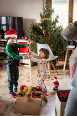 two children quarrelling over a christmas bauble at home
