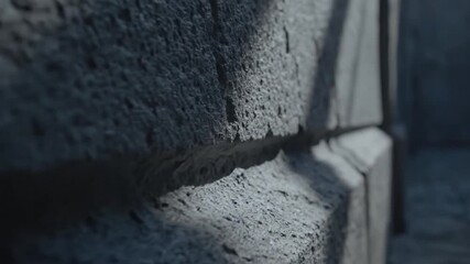 Closeup of rough grey stone wall texture with deep shadows and porous surface - Powered by Adobe