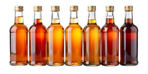 Six glass bottles filled with amber liquid arranged in a row against a black background studio shot on transparent background