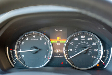 Fototapeta premium Car dashboard with fuel low warning and illuminated indicators