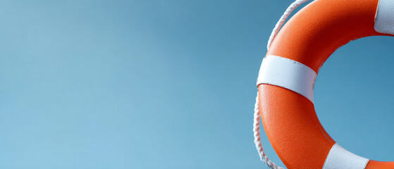 Close-up of orange and white lifebuoy against clear blue sky background with space for text