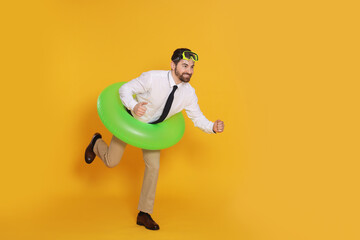 Businessman with diving mask and inflatable ring on orange background, space for text