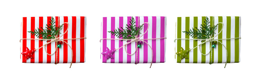 PNG image of Three colorful christmas gifts wrapped in striped paper with twine star ornaments and evergreen sprigs create a festive holiday scene for celebrations and giving on transparent background
