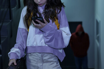 Child in danger. Girl using phone while man stalking her indoors, selective focus