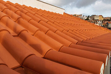 View of a new clay tile roof. Close-up of terracotta roof tiles