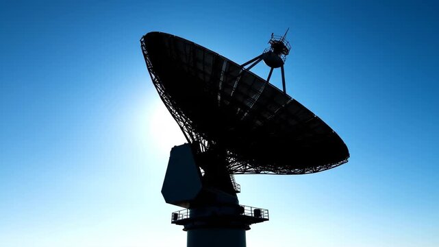 Silhouette of communications technology antenna against backdrop of cloudless sky, communications technology antenna features parabolic reflector for receiving signals.